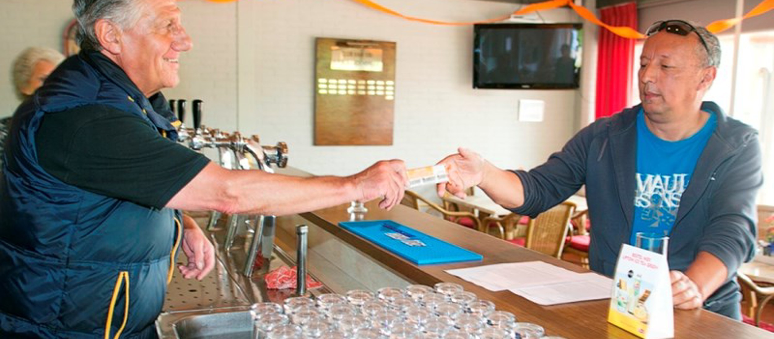 Vrijwilliger helpt tennisser aan de bar