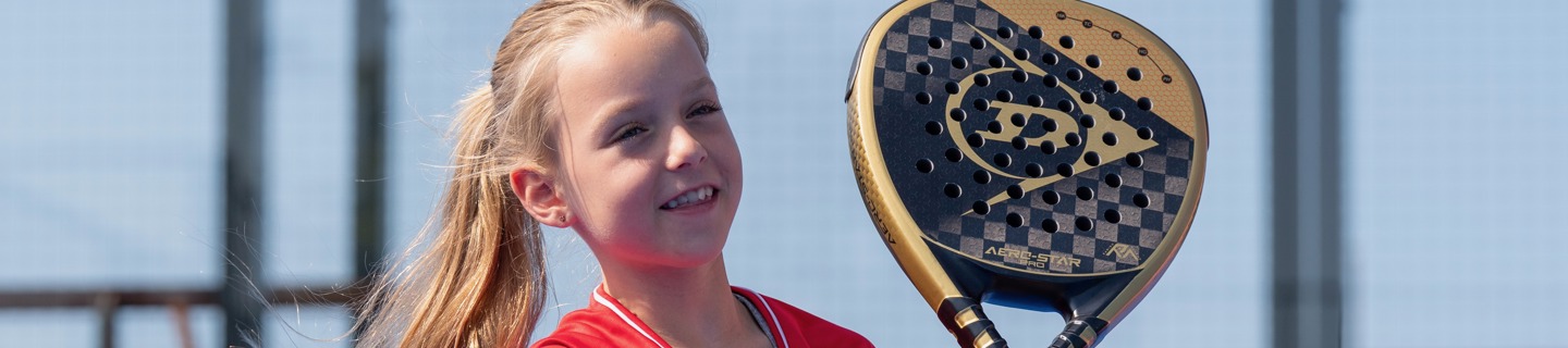Meisje met padelracket aan het net