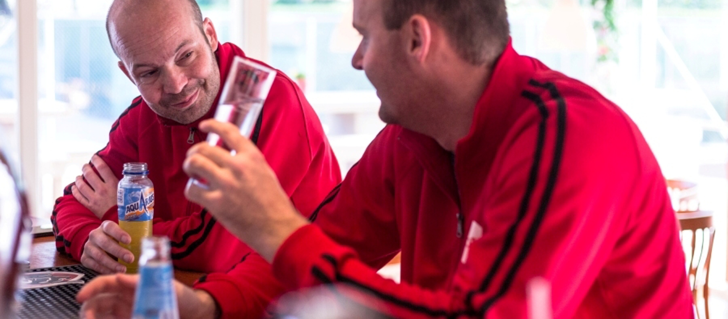 Mannen zitten aan bar met drankje